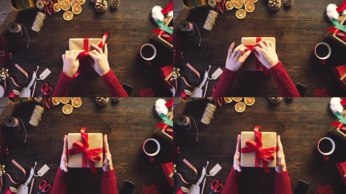 4k视频片段，一个无法识别的女人独自坐在工作室里包裹着圣诞节礼物