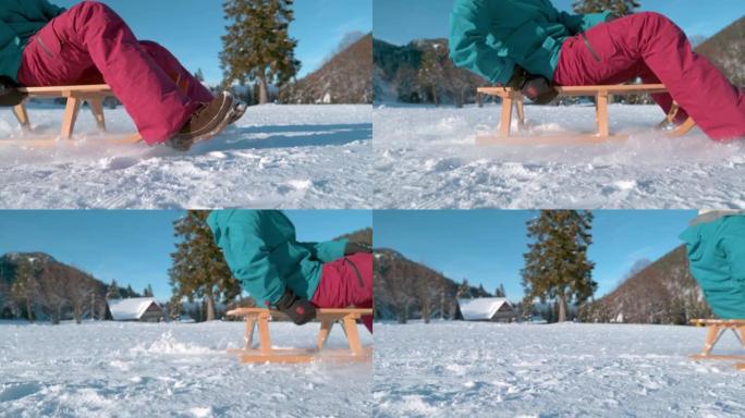 低角度，特写: 无法辨认的年轻女子雪橇穿过白雪皑皑的草地。