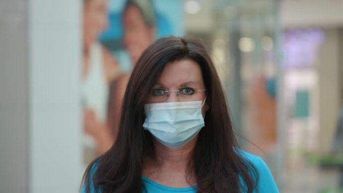 购物中心一名熟女戴着防护口罩防止新型冠状病毒肺炎冠状病毒大流行的全景肖像