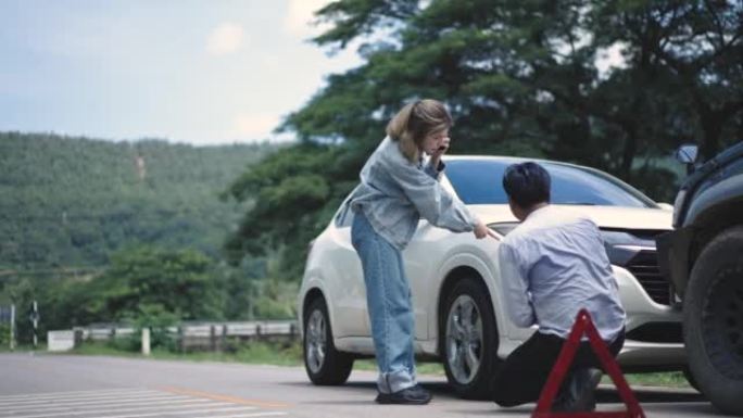 年轻的亚洲妇女和保险代理人讨论汽车损坏和保险索赔