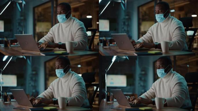 黑人非裔美国人在创意机构的笔记本电脑上进行在线对话时戴着口罩。冠状病毒大流行期间商务办公中的社会限制