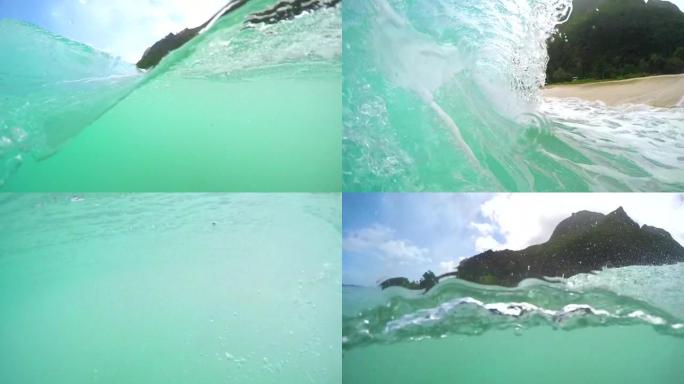 半水下: 绿松石水冲向夏威夷的热带沙滩。