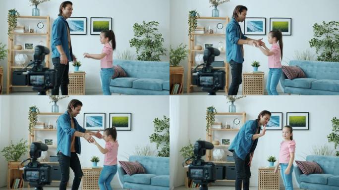 快乐的父女跳舞挥舞着手，为互联网博客录制高五视频