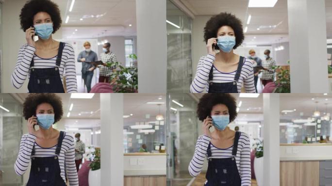 非裔美国创意女商人在办公室使用智能手机戴口罩的肖像