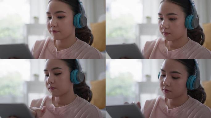 年轻的亚洲女孩在数字平板电脑上在家听学习在线播客