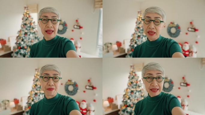 快乐的高级女人在圣诞节虚拟视频通话中问候家人。