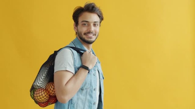 阿拉伯男子携带有机食品水果和牛奶可重复使用的购物袋的肖像