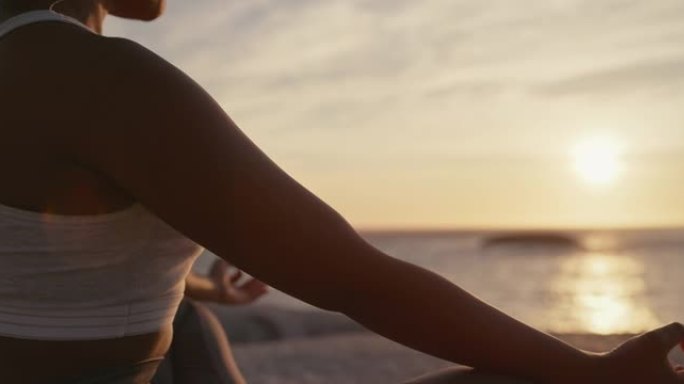 4k视频片段，一名年轻女子在海滩上练习深度冥想