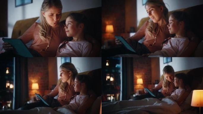 特写一位母亲在睡觉前从平板电脑上读童话给她可爱的女儿的肖像。年轻的妈妈照顾小女孩，在家阅读在线故事。