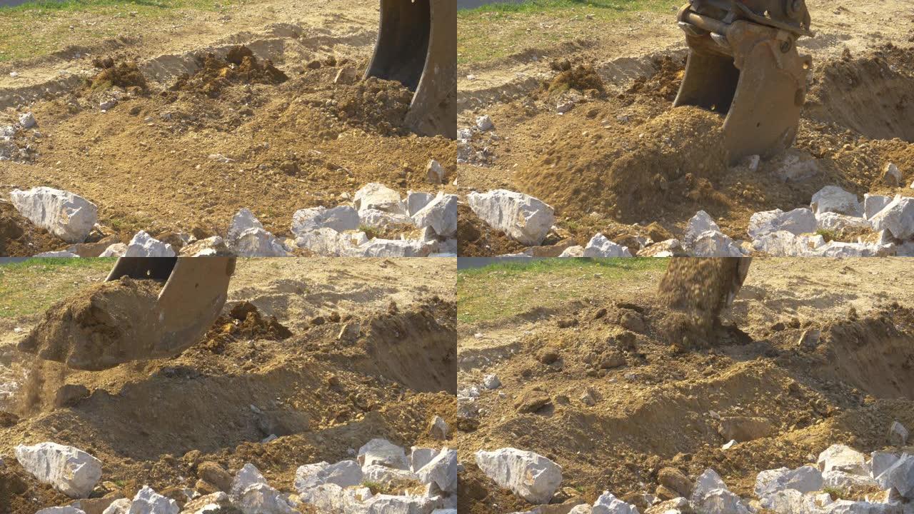 特写: 大型金属挖掘机铲斗在挖沟时铲起泥土。
