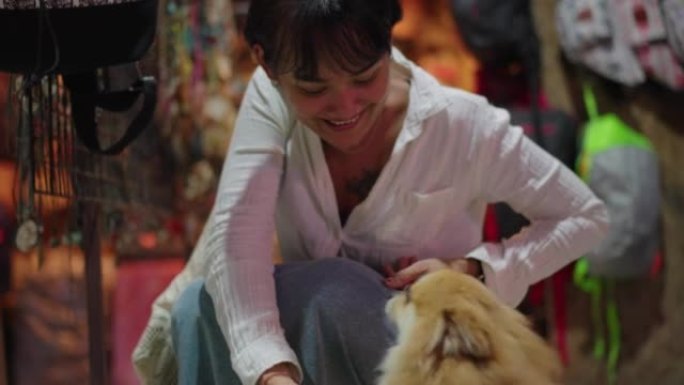 微笑的女人在和一只狗玩耍
