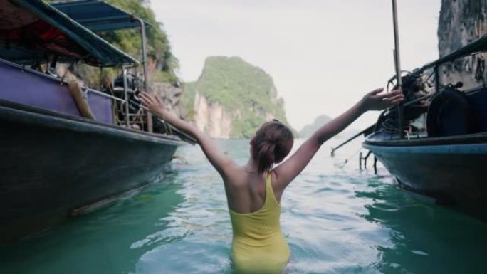 快乐的女人喜欢在热带岛屿的海边乘船。