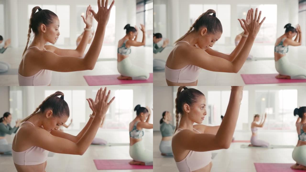 妇女练习瑜伽并在禅宗工作室课上伸展她的背部。各种各样的瑜伽士坐在垫子上，找到内在的心理平衡与和平。平