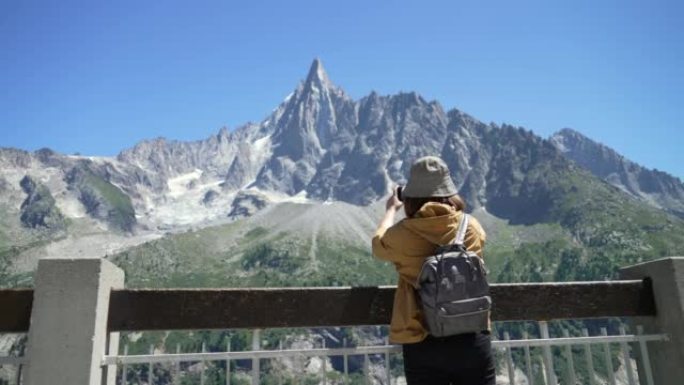 女旅行者在法国夏慕尼勃朗峰用智能手机拍照