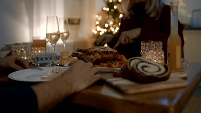 夫妇在圣诞节期间在餐桌上吃烤鸡