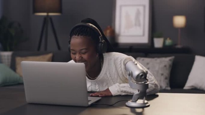 一名年轻女子在家中使用笔记本电脑和麦克风录制播客的4k视频片段