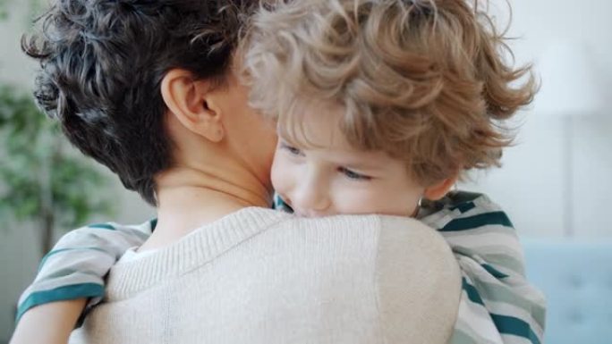 可爱孩子拥抱年轻母亲的慢动作在家里表达爱