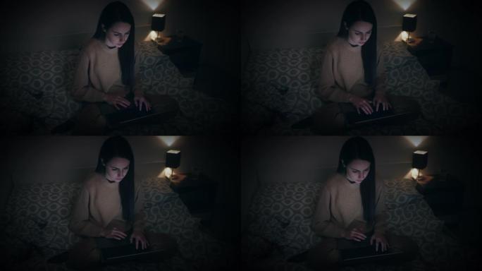 女人深夜在家床上使用笔记本电脑