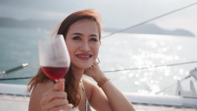 在帆船上享受酒杯的女人