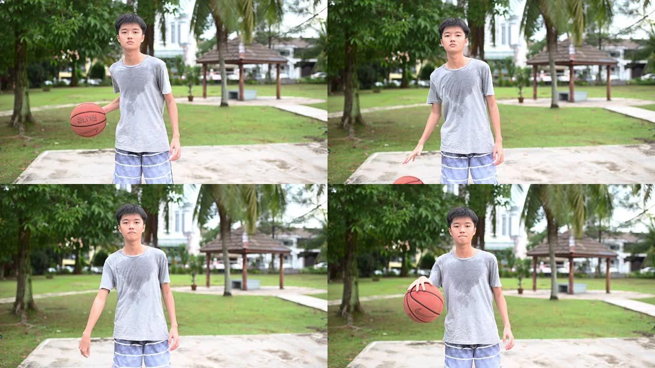 一个亚洲中国十几岁的男孩在篮球比赛后汗流浃背，他的朋友们在篮球场的户外看着相机