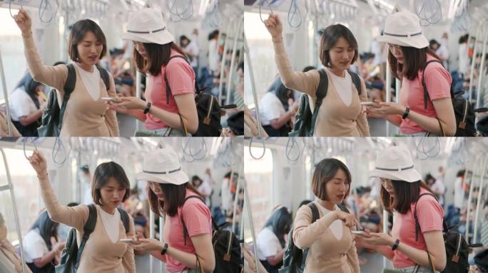 两名亚洲妇女在火车上旅行时说话和使用智能手机，慢动作