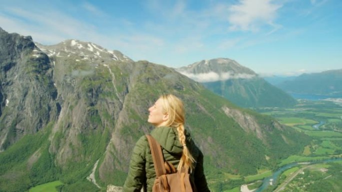 4k视频片段，一名年轻女子在Romsdalen周围徒步旅行时欣赏山景