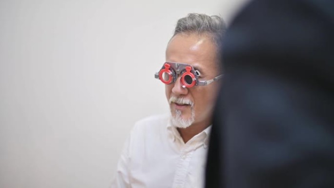在眼科诊所检查视力的亚洲中国高级男子患者