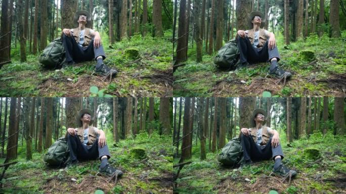 妇女坐在树旁在森林中放松