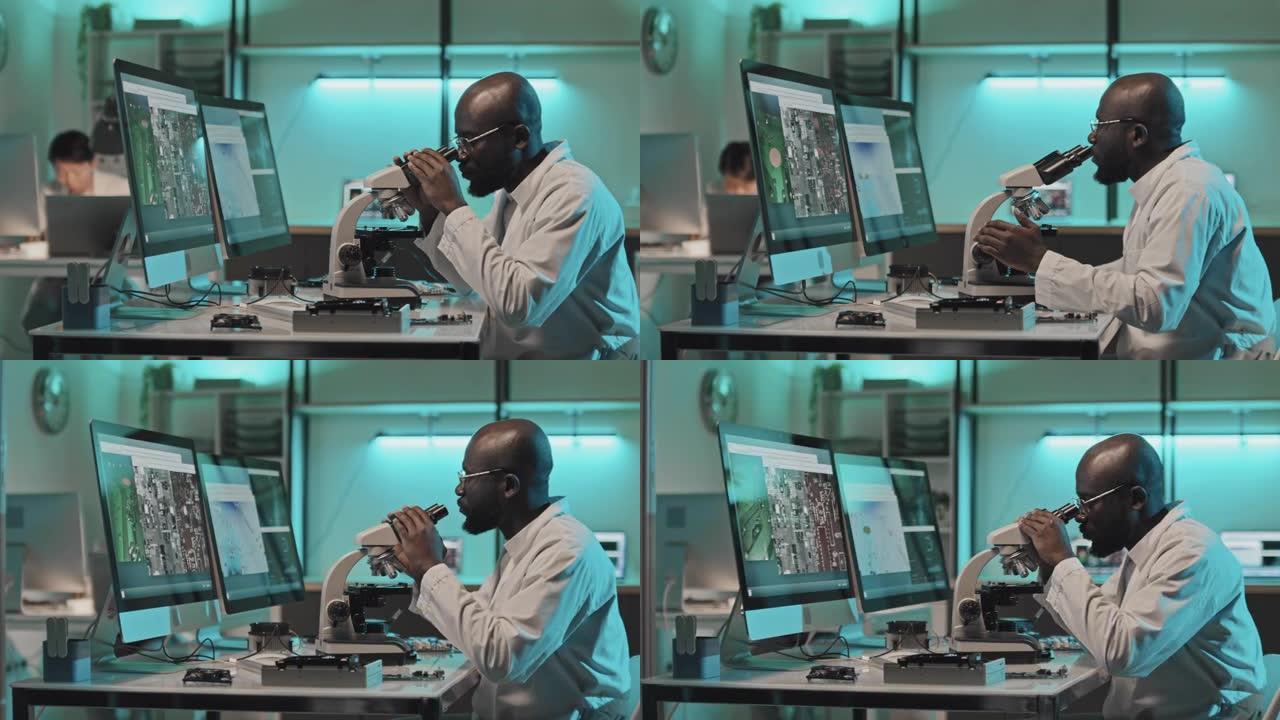 电子工程师在实验室中使用显微镜连接到计算机