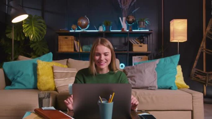直播博客。快乐年轻美丽的20多岁女性视频记录器使用笔记本电脑视频通话挥手，在家与粉丝交谈。