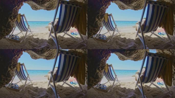 女士年轻女子在克罗地亚亚得里亚海阳光海滩的洞穴入口的折叠椅上放松