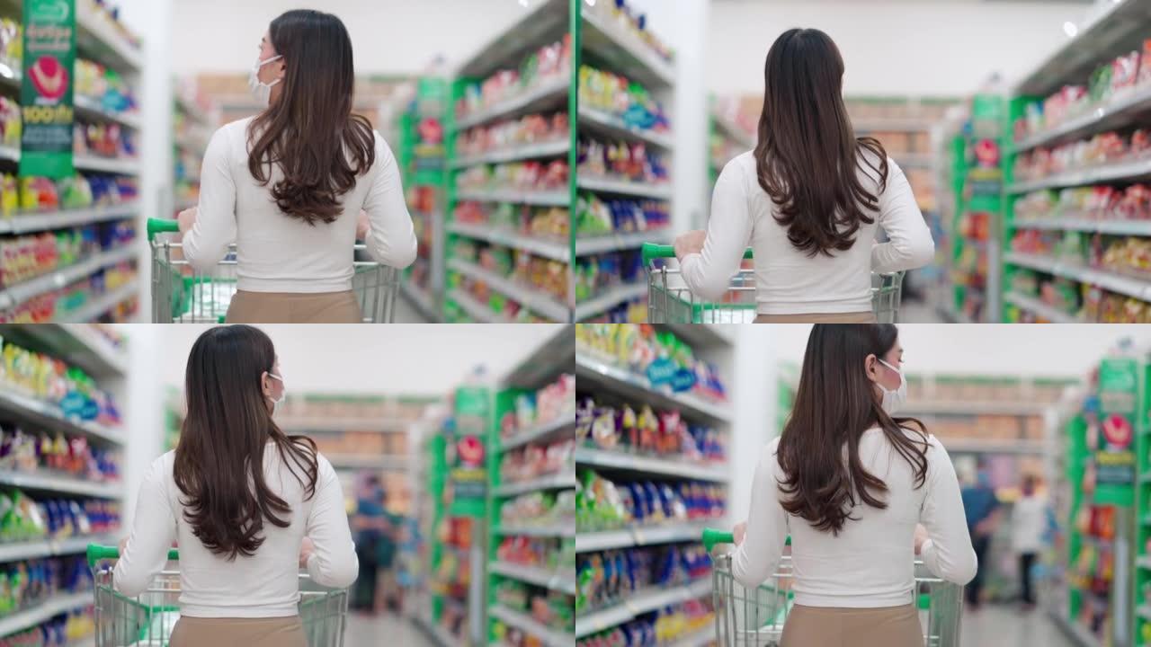 超市里有购物车的女人的后视图
