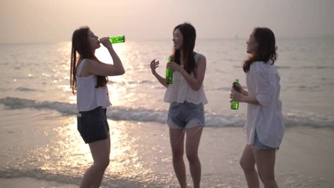 一群女人的幸福和派对在沙滩上与日落和喝酒