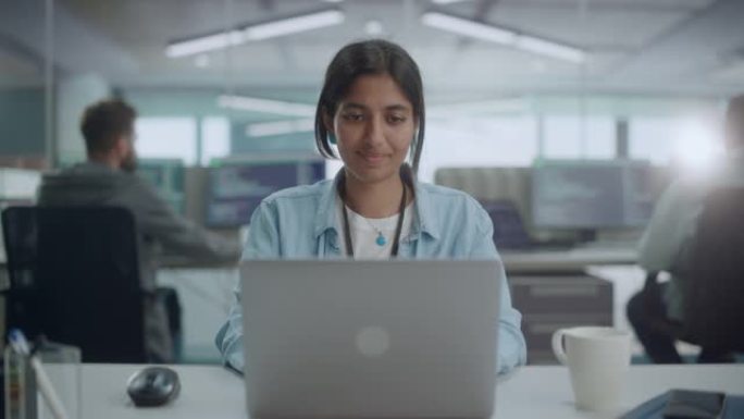 多元化的办公室: 微笑的印度IT程序员在台式计算机上工作的肖像。女专家创造创新软件。专业工程师开发鼓