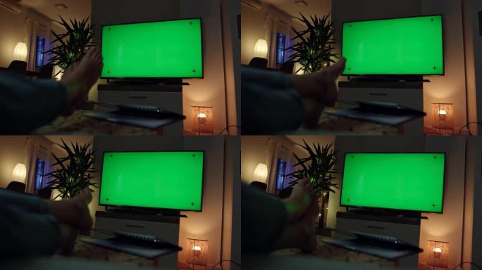 女士无法辨认的女人在看带有色度键绿色屏幕的电视