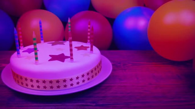 派对灯光下的生日蛋糕和气球