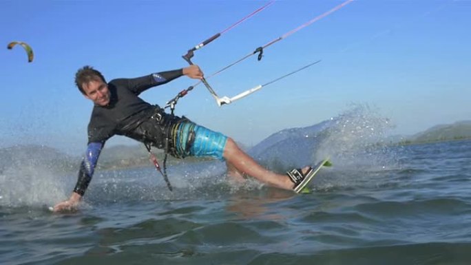 慢动作: 风筝冲浪者向相机喷水