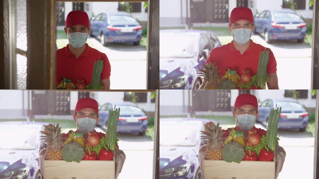 肖像: 门打开后，戴口罩的快递员抬起一盒农产品。