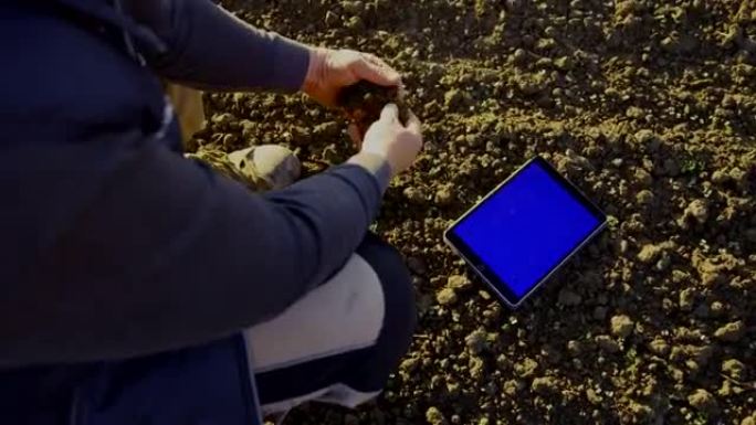 SLO MO Farmer使用带有色度键背景白色的数字平板电脑检查土壤质量