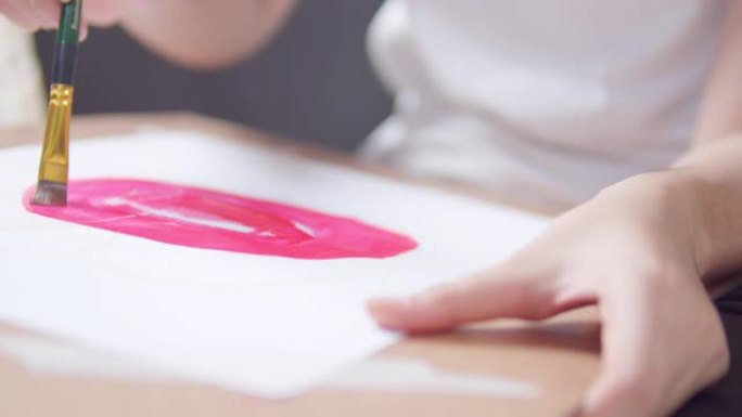 特写亚洲少女在家时，在客厅手工绘画和绘画她的艺术和工艺。她用水彩和画笔在白纸上创作艺术作品，形成了她