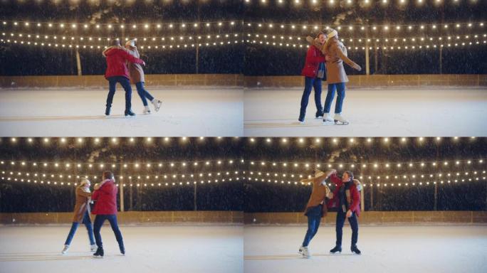 浪漫的冬夜: 滑冰夫妇在溜冰场上玩得开心。美丽的雪落在双人滑冰男孩和恋爱中的女友上，跳舞，牵手，拥抱