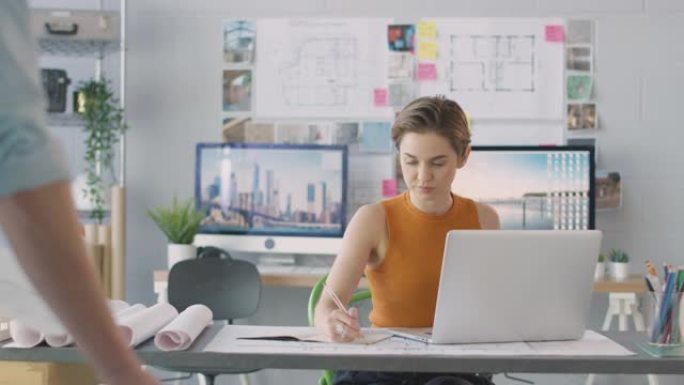办公室的男女建筑师在笔记本电脑和台式计算机上的办公桌上工作