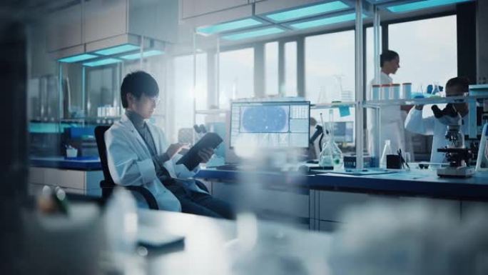 医学发展实验室: 东亚男性科学家肖像使用触摸屏数字平板电脑，做数据分析研究。先进科学实验室的生物技术