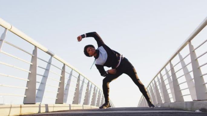非裔美国人在户外锻炼，站在行人天桥上从腰部伸展