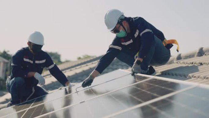 两名技术人员在金属支架上安装太阳能电池板。