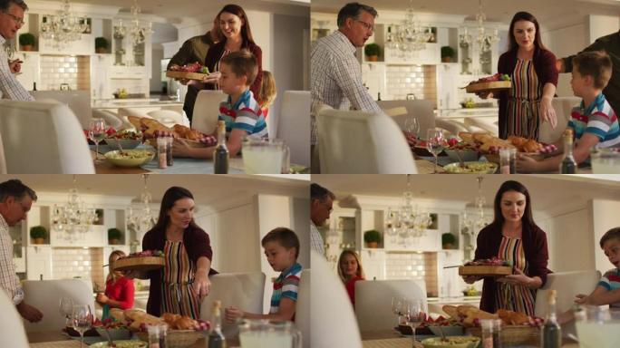 快乐的高加索父母，孩子和祖父为家庭用餐准备餐桌