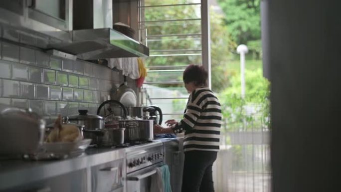 中国高级妇女在厨房为家人准备食物