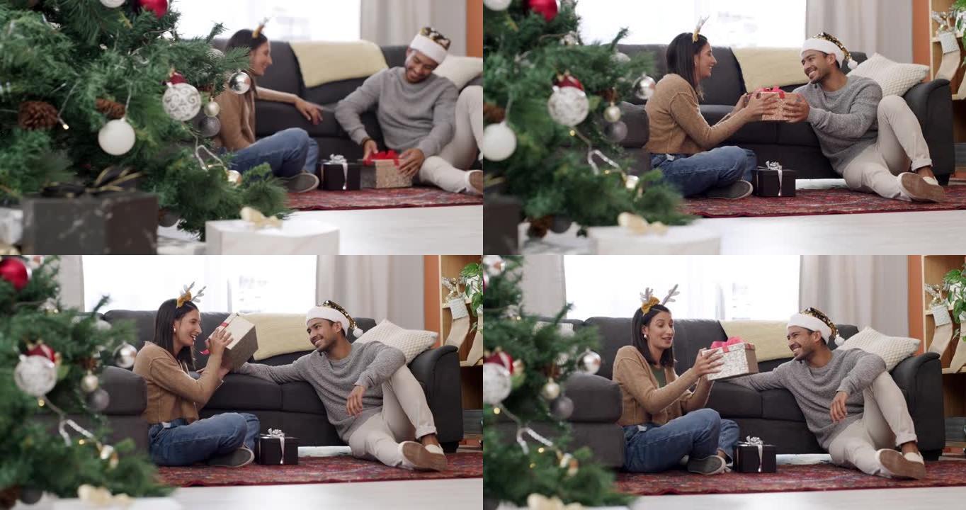 一对年轻夫妇坐在休息室地板上在家一起交换圣诞礼物的4k视频片段