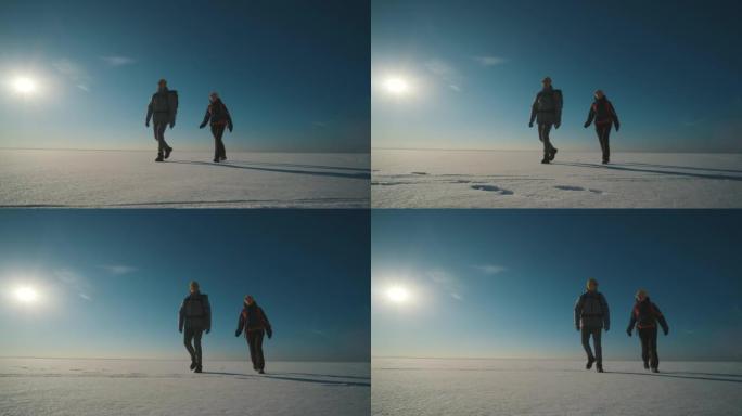 背着背包的男人和女人走过白雪皑皑的田野。慢动作