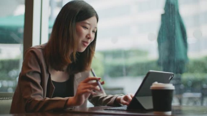 亚洲女商人在咖啡馆使用数字平板电脑